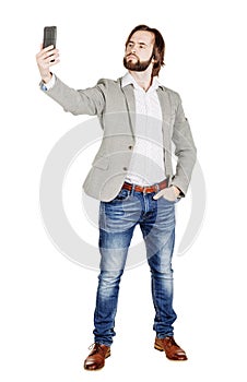 bearded young business man taking selfie smiling. portrait isolated over white studio background.