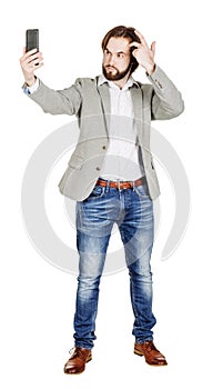 bearded young business man taking selfie smiling. portrait isolated over white studio background.