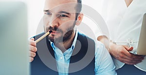 Bearded young businessman working on modern office. Consultant man thinking looking in monitor computer. Manager coworking on work