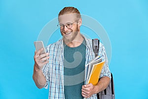 Bearded young man glasses hold modern smart phone smile at screen skype call