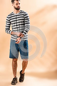 Bearded young man posing in striped sweatshirt