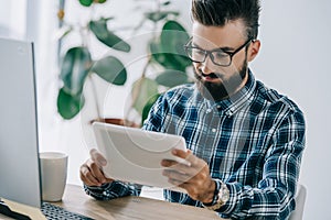 bearded young seo using tablet