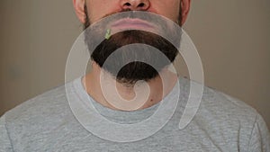 Beared man eats a hamburger