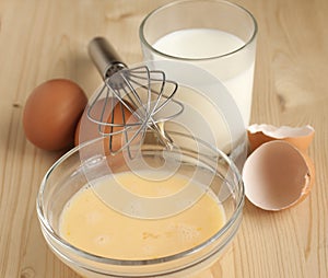 Beat eggs with milk in a glass bow