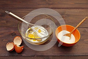 Beat eggs with milk to make dough on rustic table