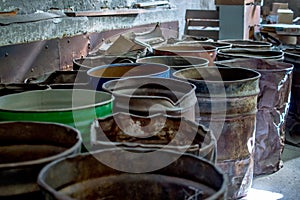 Beat up metal barrels in an old warehouse