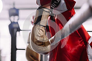 Beaten boxer in yellow boxing gloves leaning on ropes