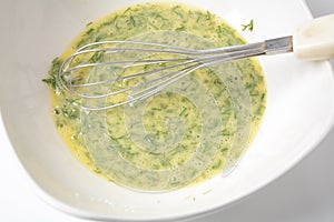 Beaten egg yolks in a bowl with whisk