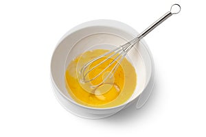 Beaten egg yolks in a bowl with whisk