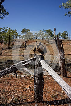 Beaten up Australian bushmans` hat on fence.