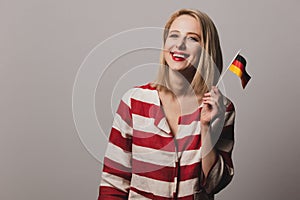 Beatiful blonde girl holds German flag in hand