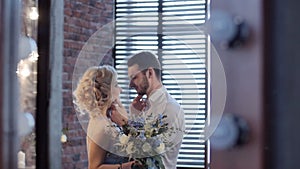 Beatiful bride and groom kissing in the stylish interior. Shot thru make up mirror