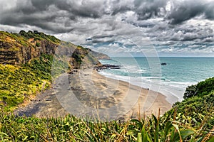 Beatiful empty black sand beach at Maori bay near Muriwai beach, New Zealand