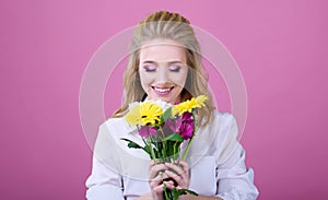Beatiful girl with a beatiful flowers on a pink background