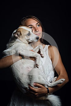 Beatiful girl holding a cute dog in her arms