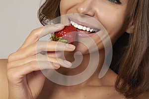 Beatiful girl with Perfect smile eat red strawberry white teeth and healthy food
