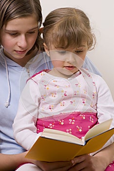 Beatiful sisters reading book
