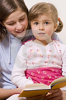 Beatiful sisters reading book