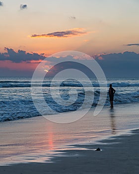 Beatiful sunset and silhouette of a man on Seminyak beach