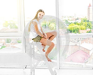 Cute teen girl sits on stepladder
