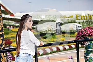 Beatiful young girl standing and enjoy flowers in Dubai Miracle Garden