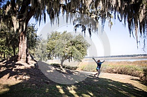 Beaufort South Carolina - spanish moss hangs in foreground as a woman jumps in the background