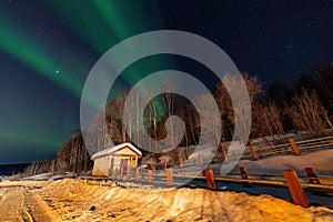 Beauitful aurora over the night sky, wooden house