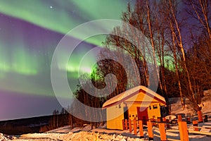 Beauitful aurora over the night sky, wooden house