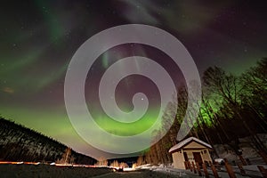 Beauitful aurora over the night sky, wooden house