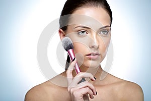 Beautful woman holding cosmetic brush