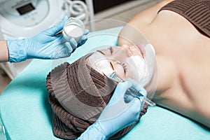 Beautician applies face mask on beautiful young woman in Spa salon. cosmetic procedure skin care. Microdermabrasion