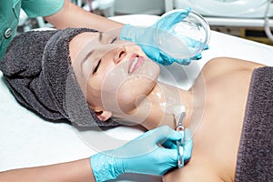 Beautician applies face mask with brush to beautiful young woman in Spa salon. cosmetic procedure skin care.