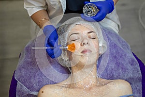 Beauty Clinic.woman gets a professional facial procedure. Beautician makes massage on a woman`s face. face renewal