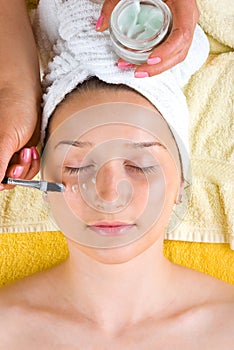 Beautician apply cream on woman eye photo