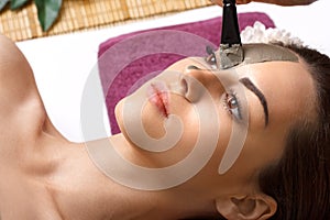 Beautician applying enzymatic peeling on woman`s face in spa photo