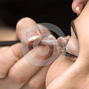 Beautician applying eye makeup