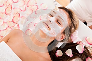 Beautician applying a face mask