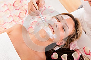 Beautician applying a face mask photo