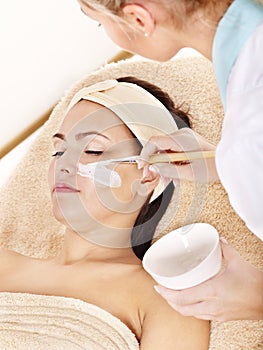 Beautician applying facial mask by woman. photo