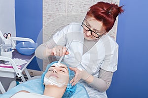 Beautician applying mask on the face