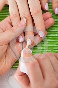 Beautician Applying Nail Varnish To Woman