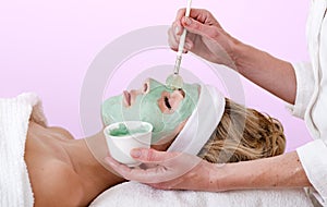 Beautician applying a thalasso face mask. photo