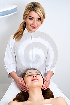 Beautician cleaning woman`s face. Spa skincare treatment. Cosmetologist with patient on medical chair. Healthy skin