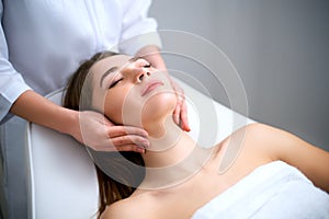 Beautician cleaning woman`s face. Spa skincare treatment. Cosmetologist with patient on medical chair. Healthy skin