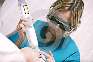 Beautician doing laser skin treatment