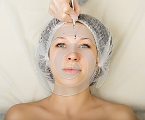 Beautician examining the face of a young female client at spa salon. face cleaning, Una cuchara. Professional photo