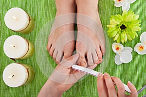 Beautician filing nails of woman