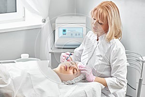 Beautician gives beauty injections to young woman in salon. Mesotherapy, biorevitalization or plasma lifting face skin close-up