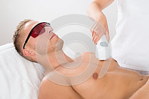 Beautician Giving Laser Epilation On Man's Chest photo