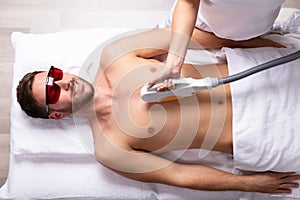 Beautician Giving Laser Epilation Treatment On Man`s Chest